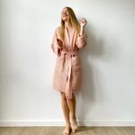 Woman wearing a short waffle cotton bathrobe with tie waist and pockets, perfect for home or spa lounging.