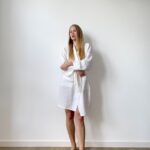 Woman in white cotton muslin robe with a wrap tie and pockets, perfect for everyday softness and ease.