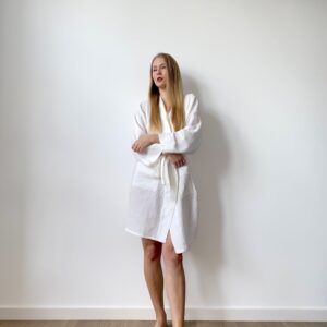 Woman in white cotton muslin robe with a wrap tie and pockets, perfect for everyday softness and ease.