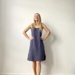 Woman in sleeveless mini muslin slip dress with relaxed silhouette, front and back views.