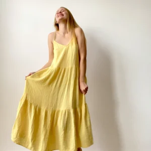 Long muslin women’s dress with flowing design and shoulder straps, ideal for warm weather and casual chic looks.
