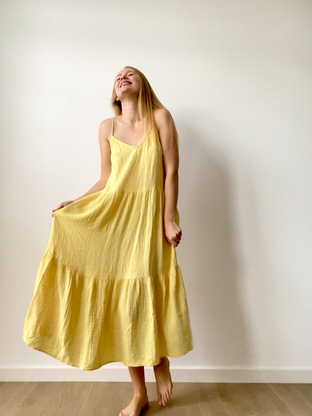 Long muslin women’s dress with flowing design and shoulder straps, ideal for warm weather and casual chic looks.