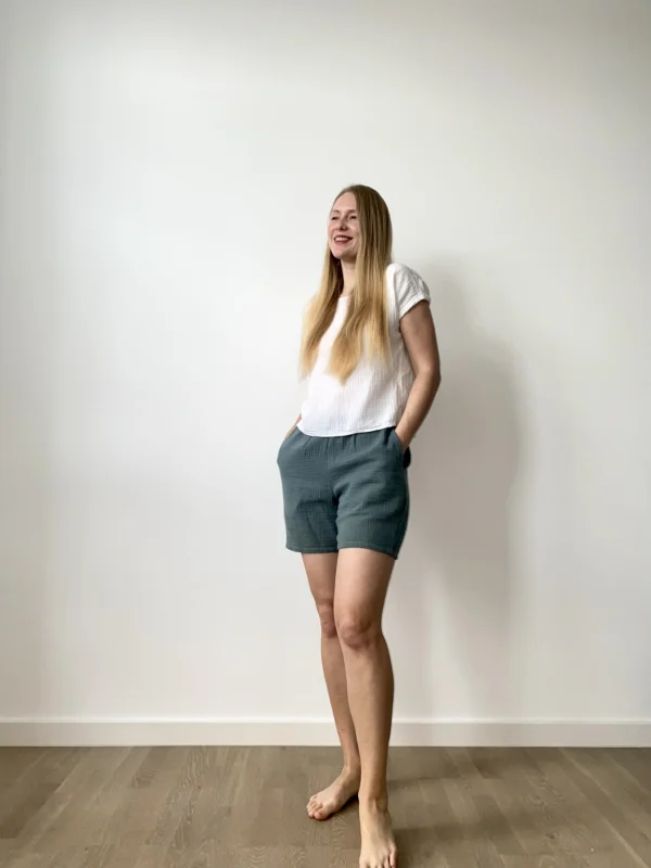 Woman wearing soft cotton muslin summer set with relaxed shorts and a short-sleeved top.