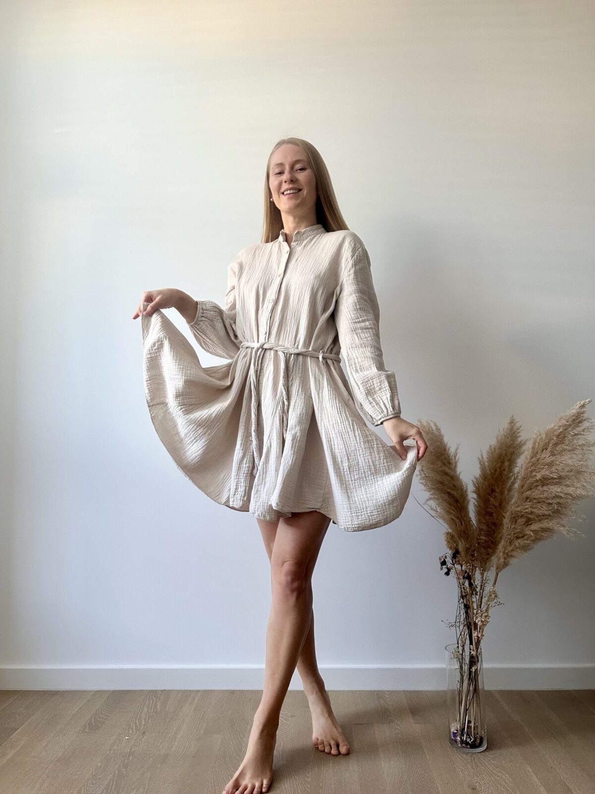 a light beige handmade muslin shirt dress with long sleeves and a tie waist