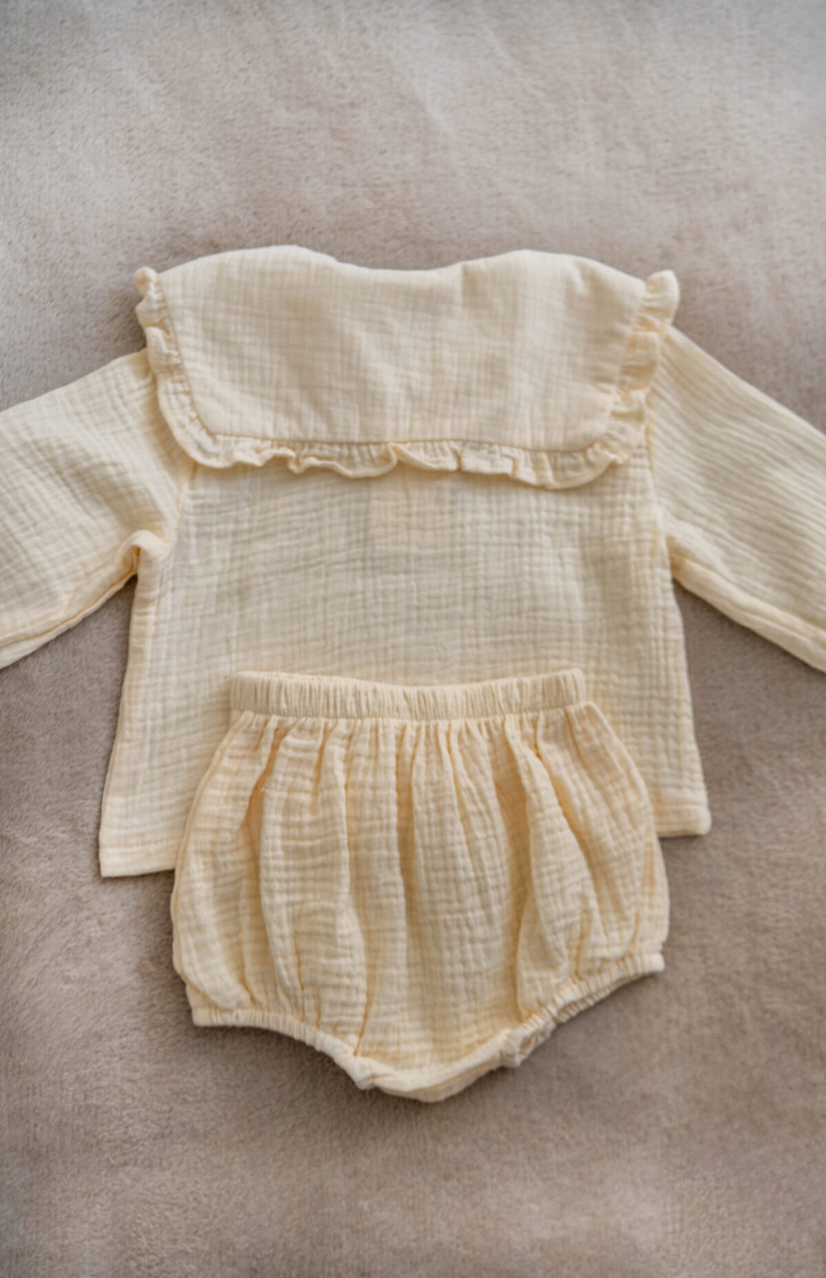 Handmade muslin baby outfit in soft neutral tones