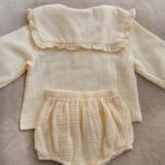 Handmade muslin baby outfit in soft neutral tones