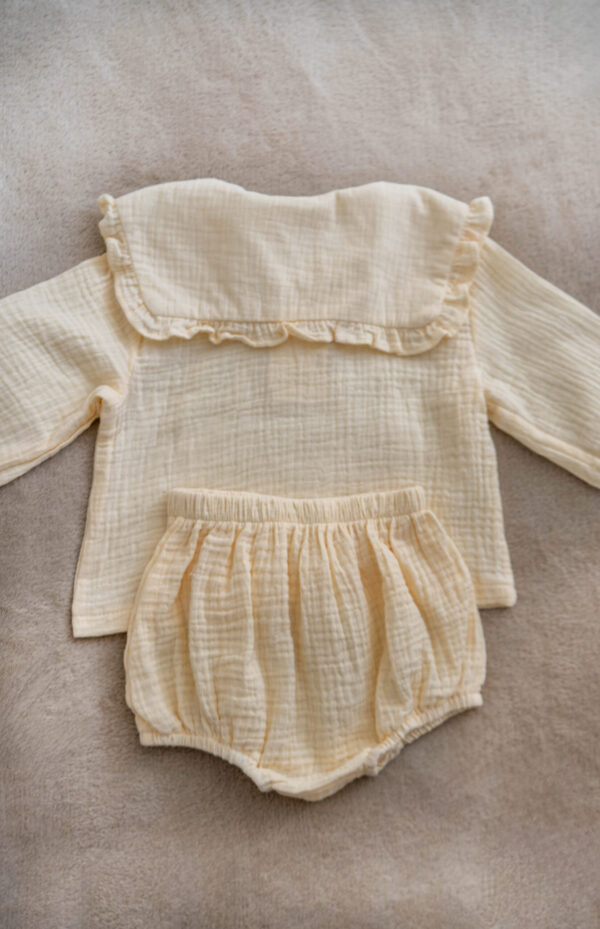 Handmade muslin baby outfit in soft neutral tones