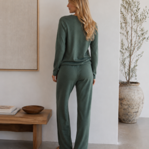 Woman wearing a green merino wool lounge set with a long-sleeve top and relaxed straight-leg trousers - back