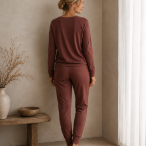 Woman wearing a burgundy merino wool lounge set with a long-sleeve top and matching trousers - back
