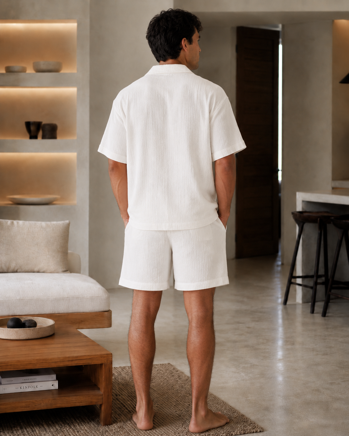 Man wearing a white cotton muslin set with a short-sleeve button shirt and matching relaxed shorts - back