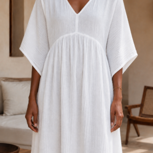 Woman wearing a flowing cotton muslin maxi dress with V-neckline, relaxed sleeves and side slit - close up