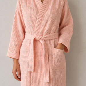 Woman wearing a lightweight waffle cotton robe with waist tie and front pockets