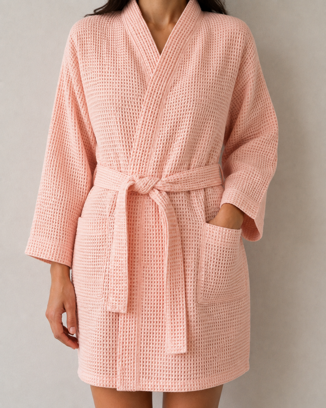 Woman wearing a lightweight waffle cotton robe with waist tie and front pockets