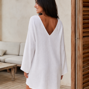 Woman wearing a relaxed cotton muslin beach cover-up dress with V-neckline and wide long sleeves - back